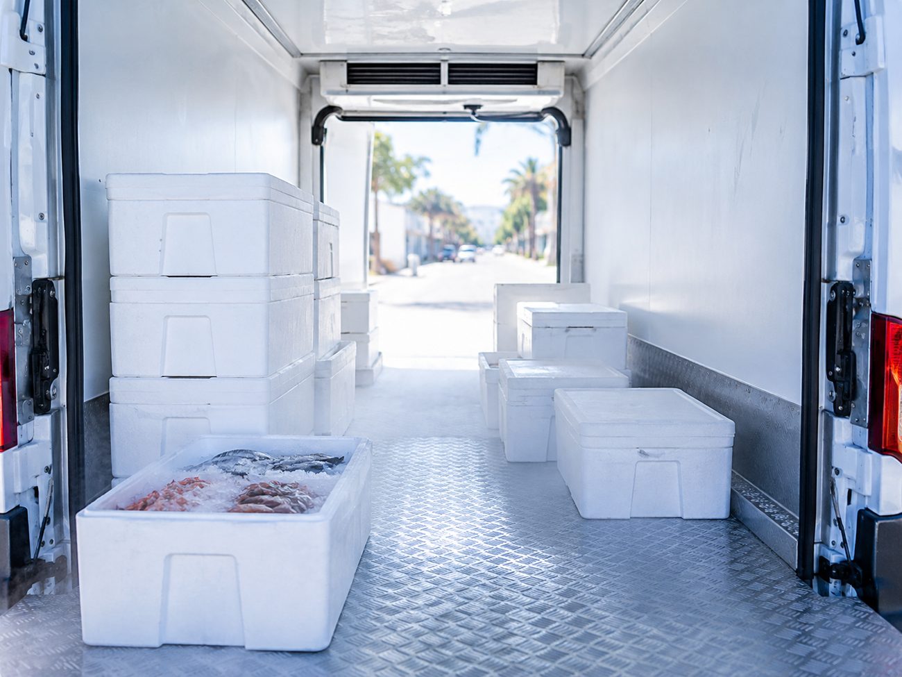Interior de un furgón refrigerado con cajas de aislapol y vaho frío
